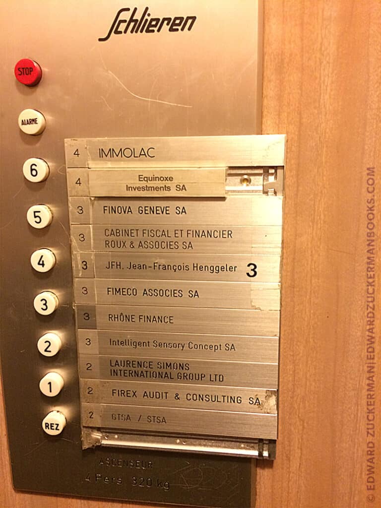 Image of a business directory made of metal name plates in the elevator | Caption reads: A typical building directory in Geneva's financial district. | credit: Edward Zuckerman